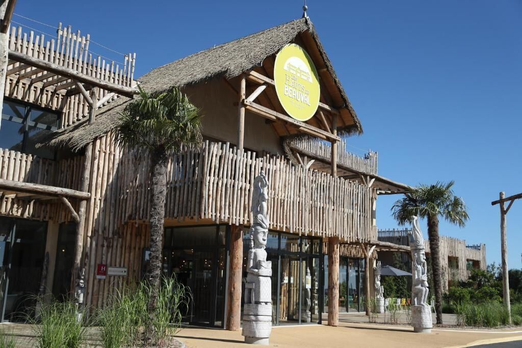 A building with a thatched roof and wooden structure, featuring a sign that reads "The Baths of Beaulieu."