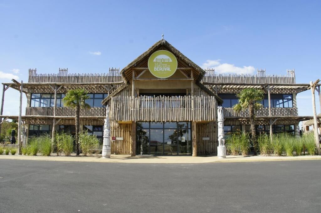 Un bâtiment doté d’un toit de chaume et d’une façade en bois, portant l’inscription « HAUTS DE BERUVAL ».