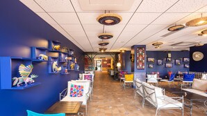 A restaurant with blue walls, hanging decorations, and a tiled floor. - Les Rivages de Beauval (Saint-Aignan)