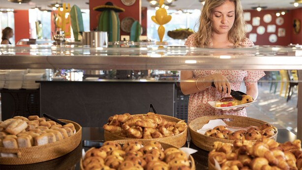A buffet area with various baked goods and a person serving themselves. - Les Rivages de Beauval (Saint-Aignan)
