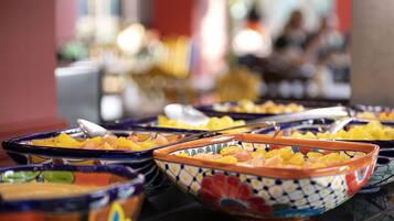 A buffet with various dishes in colorful bowls.