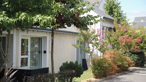 Una casa moderna de dos pisos con fachada blanca y techo gris.