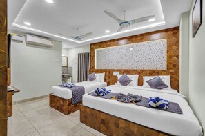 A hotel room with two beds, a wooden headboard, ceiling fans, and an air conditioning unit. - The K11 Golden Gate (Chennai)