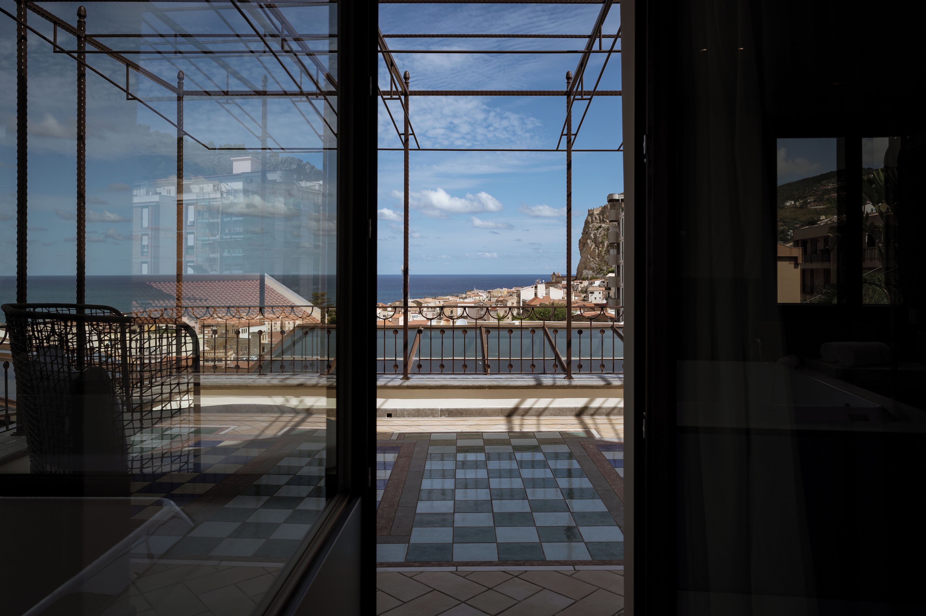 A balcony with a view of the sea and buildings.
