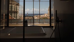 Un baño moderno con un ventanal grande, una bañera y una ducha.