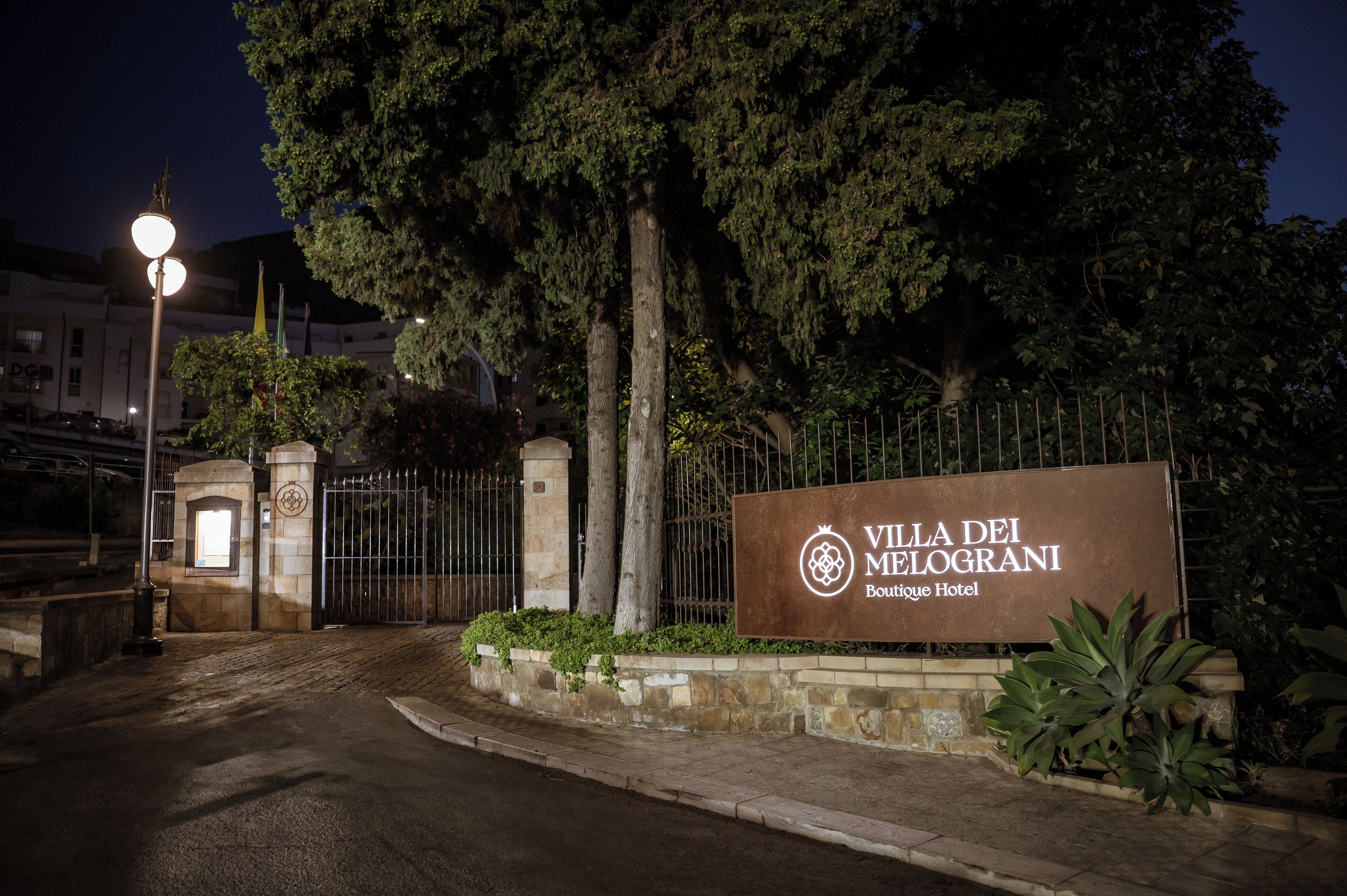 Una entrada con reja y un letrero para el Hotel Boutique Villa dei Melograni.