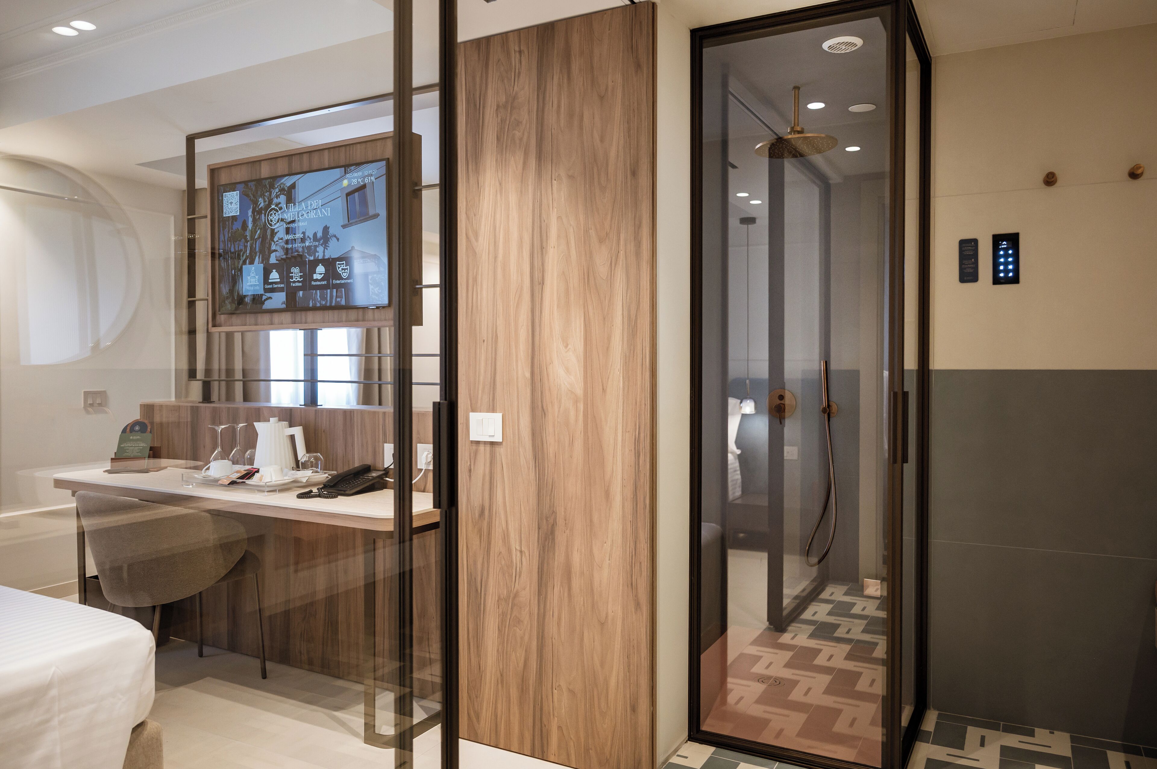 A modern bathroom with a glass-enclosed shower, a wooden panel wall, and a digital display above the sink.