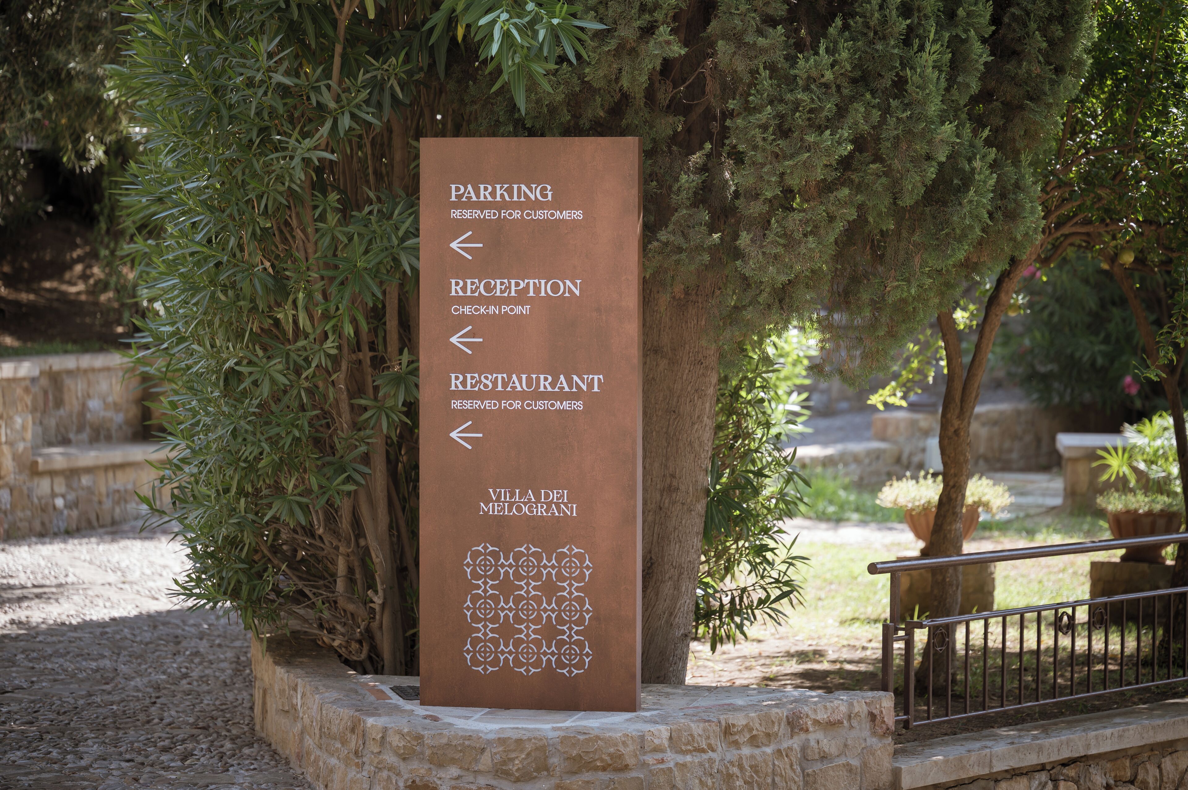 A directional sign with arrows pointing to the parking, reception, and restaurant areas, all reserved for customers.