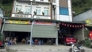 Un edificio de dos pisos con una cafetería en la planta baja y una tienda en el segundo piso.