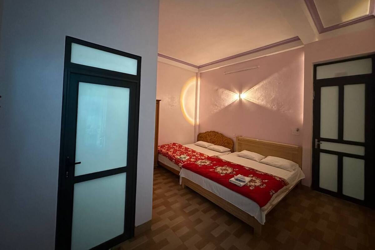 Ein Schlafzimmer mit einem Bett, einer Tür und einer Wandleuchte.