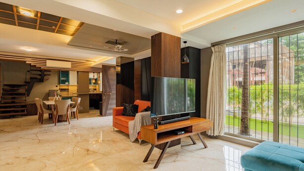 A modern living room with a TV, sofa, and dining area. - Alaya Stays - Imperial Calista 4BHK near Khandala Hills (Lonavala)