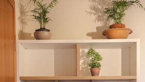 Una estantería de madera con plantas en macetas y cestas de mimbre.