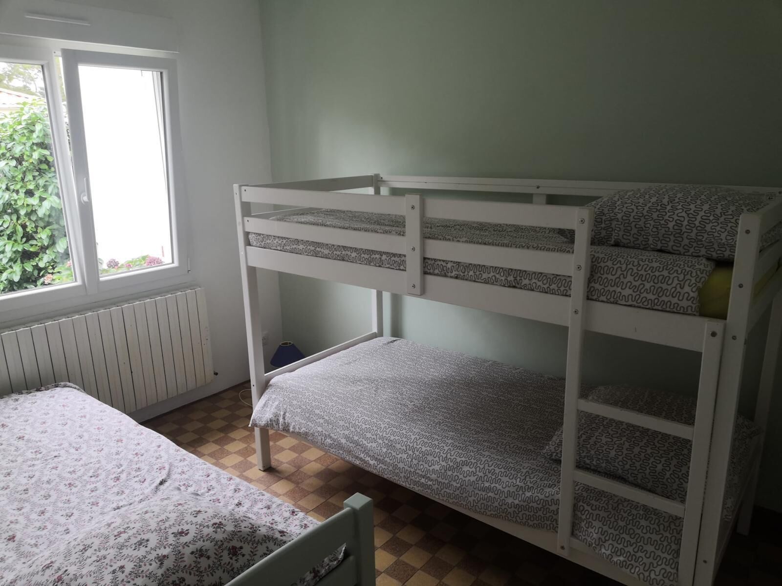 Ein Mehrbettzimmer mit Fenster und Heizkörper.