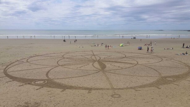 A beach with a large circular design on the sand.
