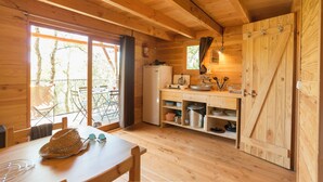 Ein Holzblock-Interieur mit Küchenbereich, Esstisch und Blick durch die Tür.