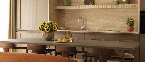 A modern kitchen with a central island, wooden cabinets, and pendant lighting.