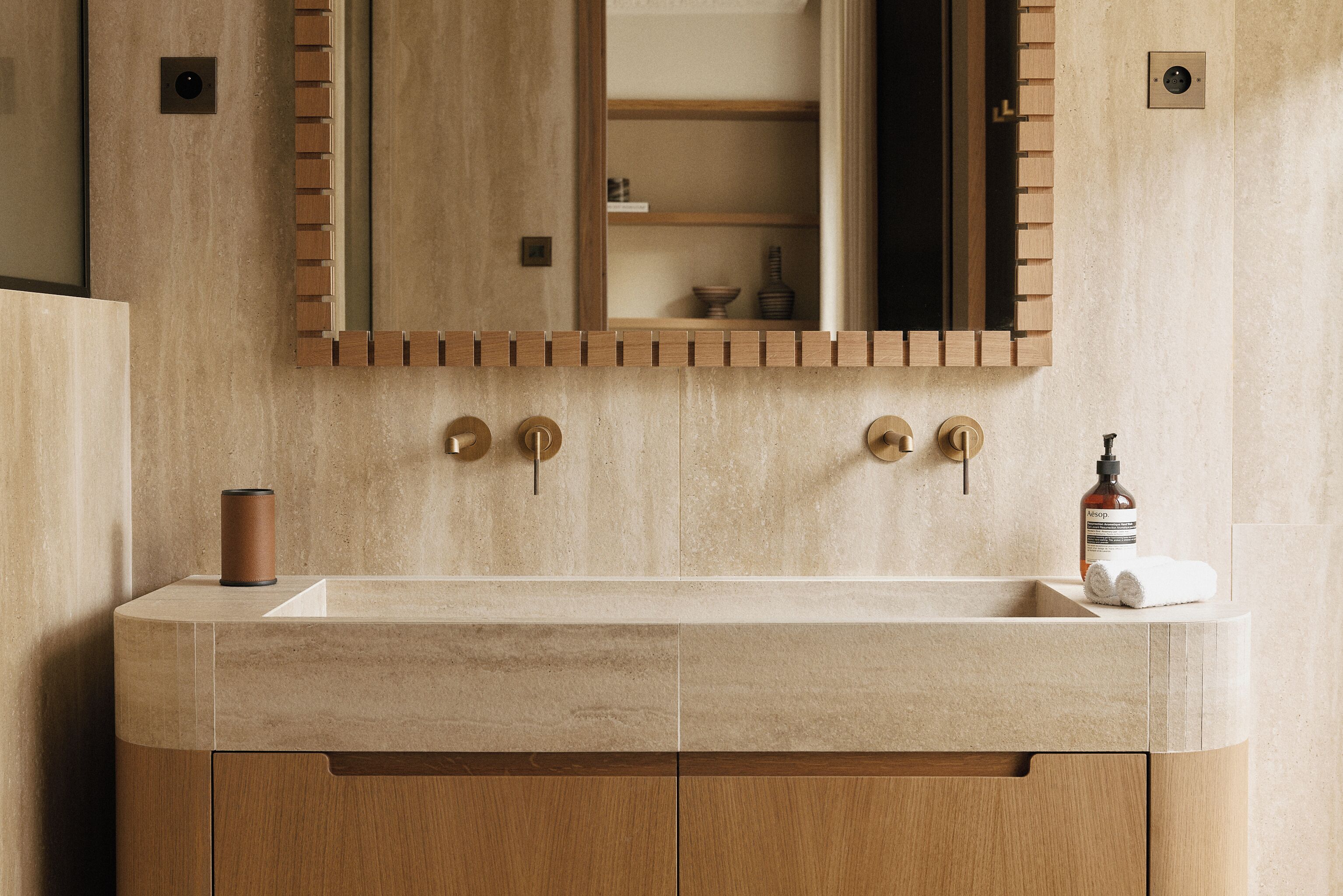 A bathroom with a wooden vanity, a large mirror, and a sink.