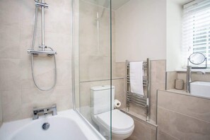 A modern bathroom with a glass shower enclosure, a white toilet, and a bathtub. - Castle Hill | Wi-Fi | Parking (Northumberland)