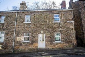 A stone building with a white door and windows, labeled 'CASTLE HILL.' - Castle Hill | Wi-Fi | Parking (Northumberland)