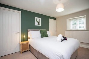 A bedroom with a bed, bedside table, lamp, and a window. - Castle Hill | Wi-Fi | Parking (Northumberland)