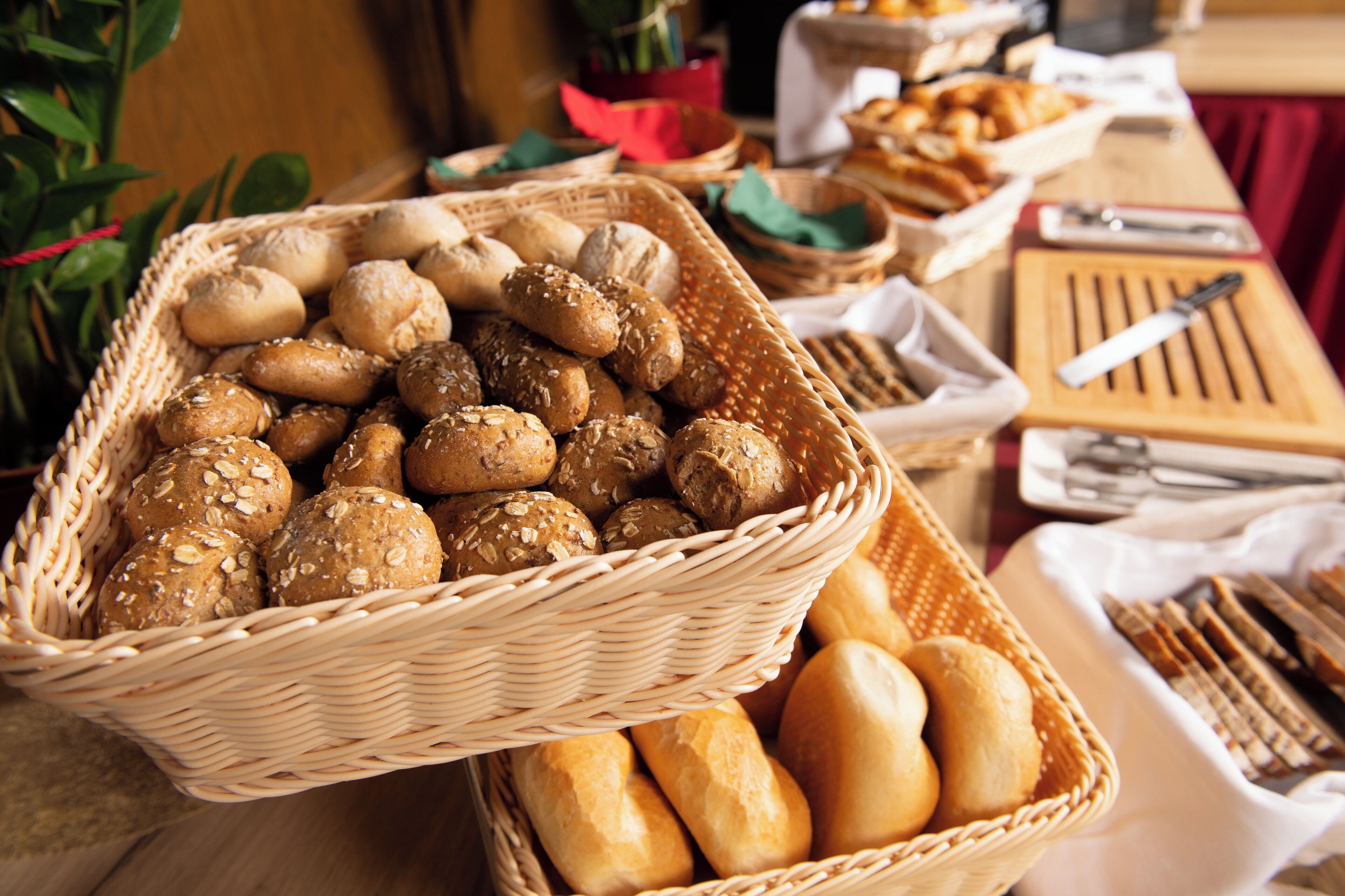 A table with various types of bread and pastries in baskets.