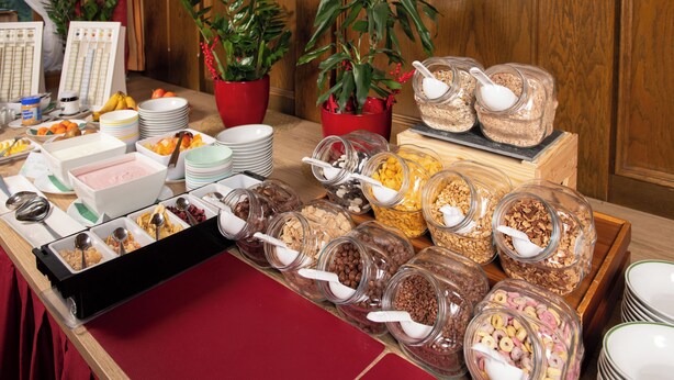 A buffet table with various food items and serving utensils.