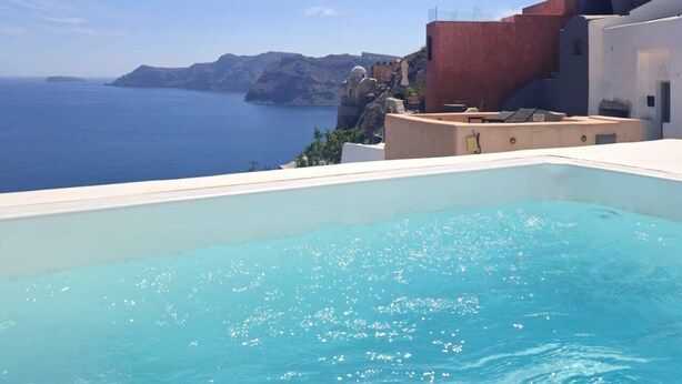 A pool with a clear view of the sea and rocky cliffs.