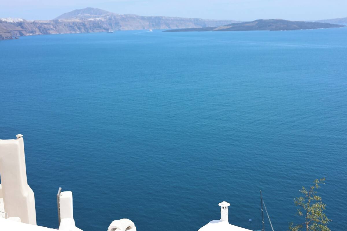 Paesaggio costiero con mare cristallino e forme del terreno in lontananza.
