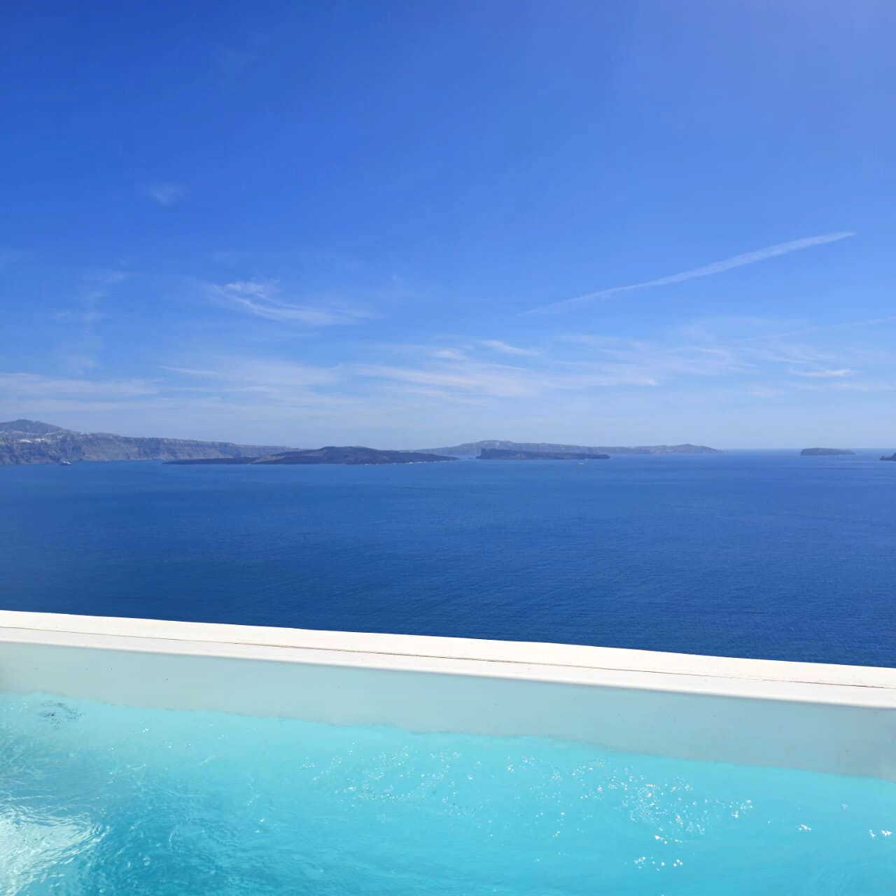 Una piscina con vistas despejadas al mar y a la costa lejana.