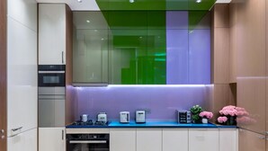 A modern kitchen with a built-in oven, a coffee machine, and a microwave on the counter.