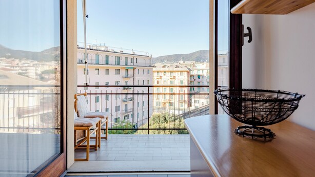 Ein Balkon mit Blick auf Gebäude und Berge.