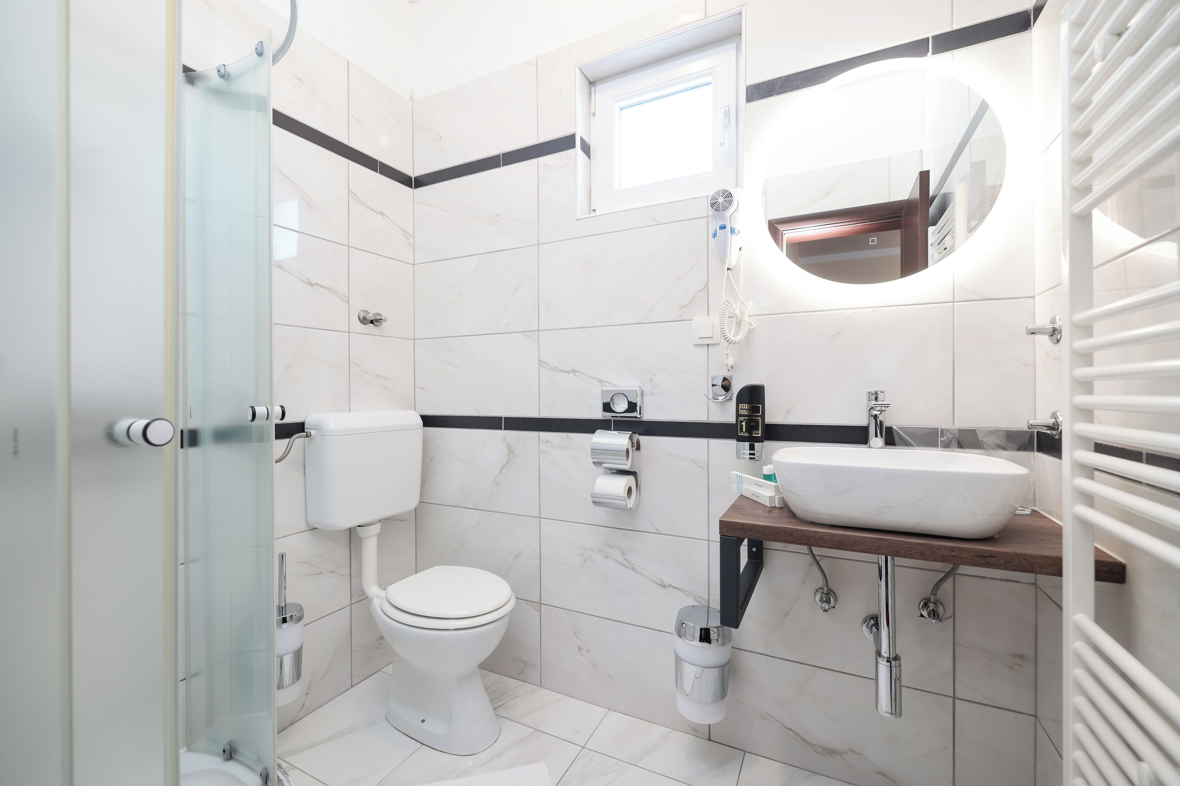 Ein modernes Badezimmer mit Toilette, Waschbecken und Dusche.
