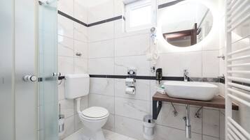 Ein modernes Badezimmer mit Toilette, Waschbecken und Dusche.