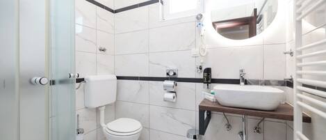 A modern bathroom with a toilet, sink, and shower.