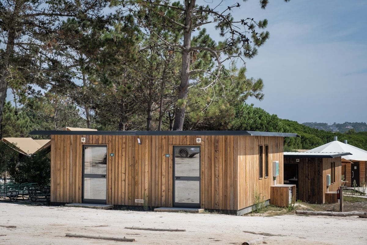 A wooden cabin with a door, windows, and a small attached structure.