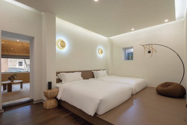 Une chambre à coucher moderne avec un grand lit, des tables de chevet et un luminaire mural original.