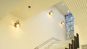 A marble staircase with black handrails and wall-mounted lighting fixtures. - Serenity By The Ganges (Haridwar)