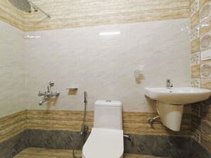 Een douche, handdoeken, zeep, toiletpapier