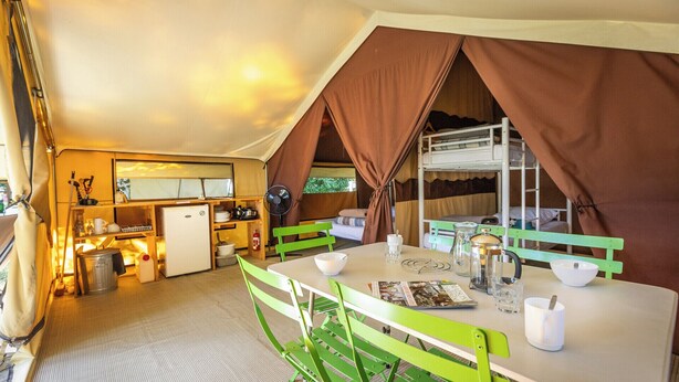 A compact kitchen with a refrigerator, sink, and dining area with green chairs and a table. - Huttopia Oléron les Chênes Verts  (Dolus-d'Oléron)