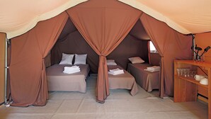 A tented accommodation with two beds, each with pillows and folded towels. - Huttopia Oléron les Chênes Verts  (Dolus-d'Oléron)