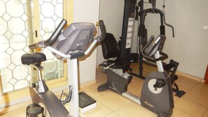A gym with stationary bikes, a treadmill, and a weight machine.