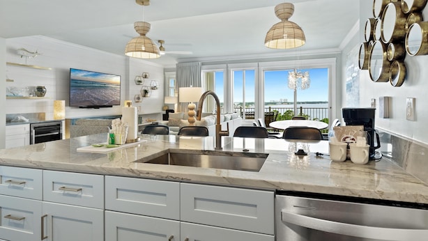 Una cocina moderna con una isla grande, electrodomésticos de acero inoxidable y un comedor con vistas.