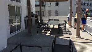 An outdoor patio area with a table and chairs, a covered seating area, and a view of the cityscape. - Hermoso estudio en Santiago (Santiago)