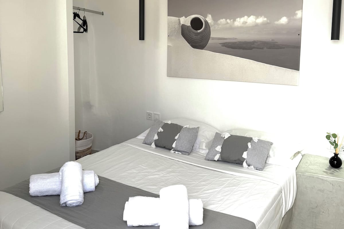 A modern bedroom with a large bed, a view of the sea, and a minimalist design.