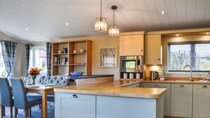 Una cocina moderna con una isla central, estanterías empotradas y una zona de comedor con sofá.