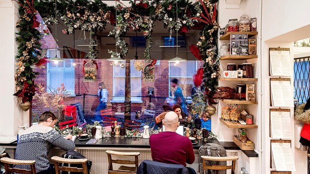 A restaurant with a festive Christmas decoration, a brick wall, and a menu board. - The King of Spades - by Out of Office Lifestyle (London)