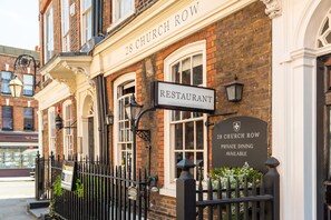 Un edificio de ladrillo con un cartel que dice "28 CHURCH ROW PRIVATE DINING AVAILABLE".