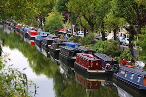 Un canale fiancheggiato da houseboat ormeggiate lungo l'acqua.