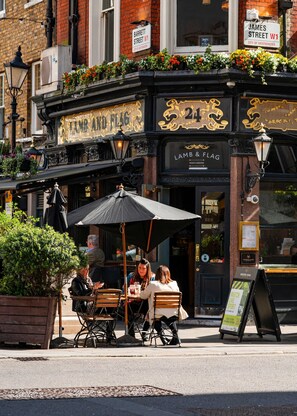 A traditional pub named 'Lamb & Flag' with outdoor seating and a black awning. - The Nordic Nook Luxury Marylebone - by Out of Office Lifestyle (London)