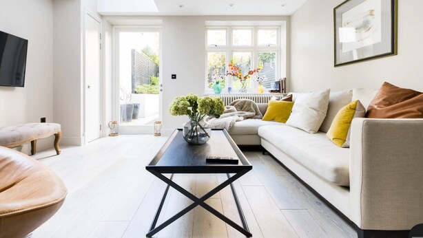 A modern living room with a sofa, coffee table, and a TV mounted on the wall. - The English Gentleman Hampstead Heath - by Out of Office Lifestyle (London)